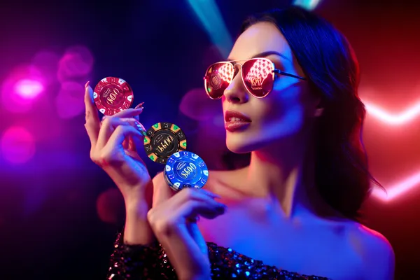 Một cô gái mỉm cười khi chơi game trên laptop với các biểu tượng casino xung quanh, thể hiện bộ sưu tập trò chơi đa dạng của ZBET BET.